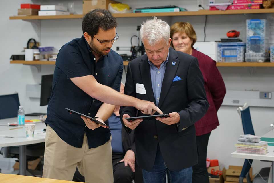 College Spotlight A faculty member presents a device in a lab.