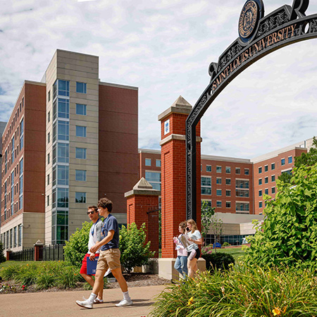 A family walks through the SLU Gates on Grand Blvd. in from of Grand Hall