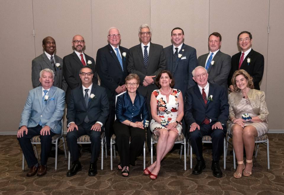 Winners pose in two rows, both seated and standing.