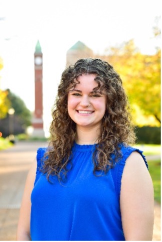 Emma Murphy stands in front of the SLU clock tower