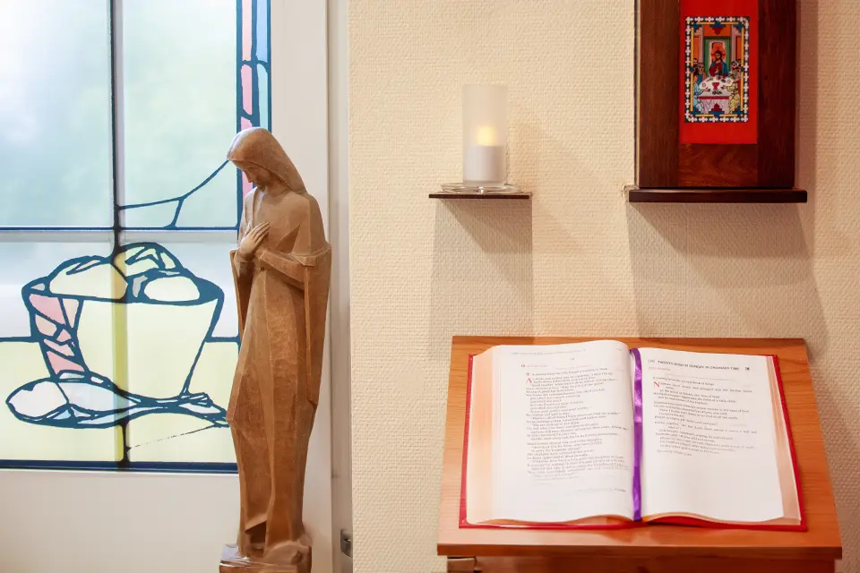 A wooden sculpture and a bible in a praying room