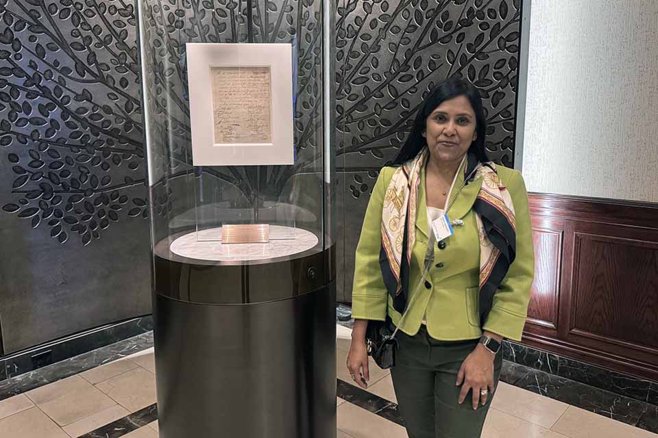 a woman standing next to a glass case